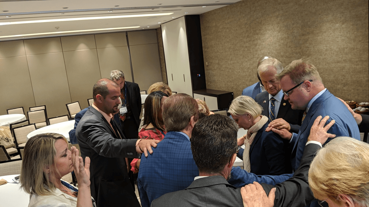 Legislators praying at the Jerusalem Prayer Breakfast