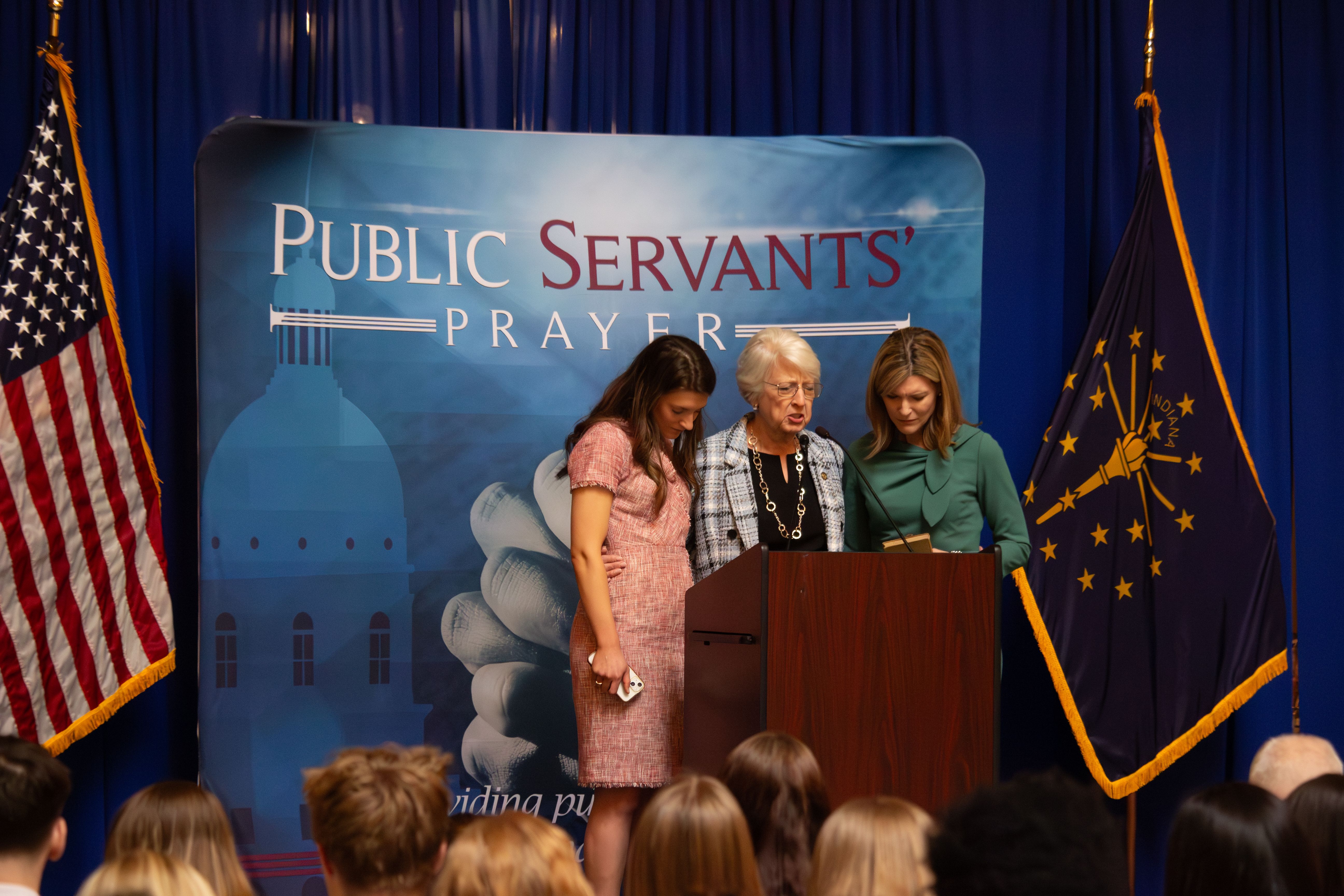 Chaplain Pamella Russell praying for Claire Neuman and her mother State Comptroller Elise Nieshalla