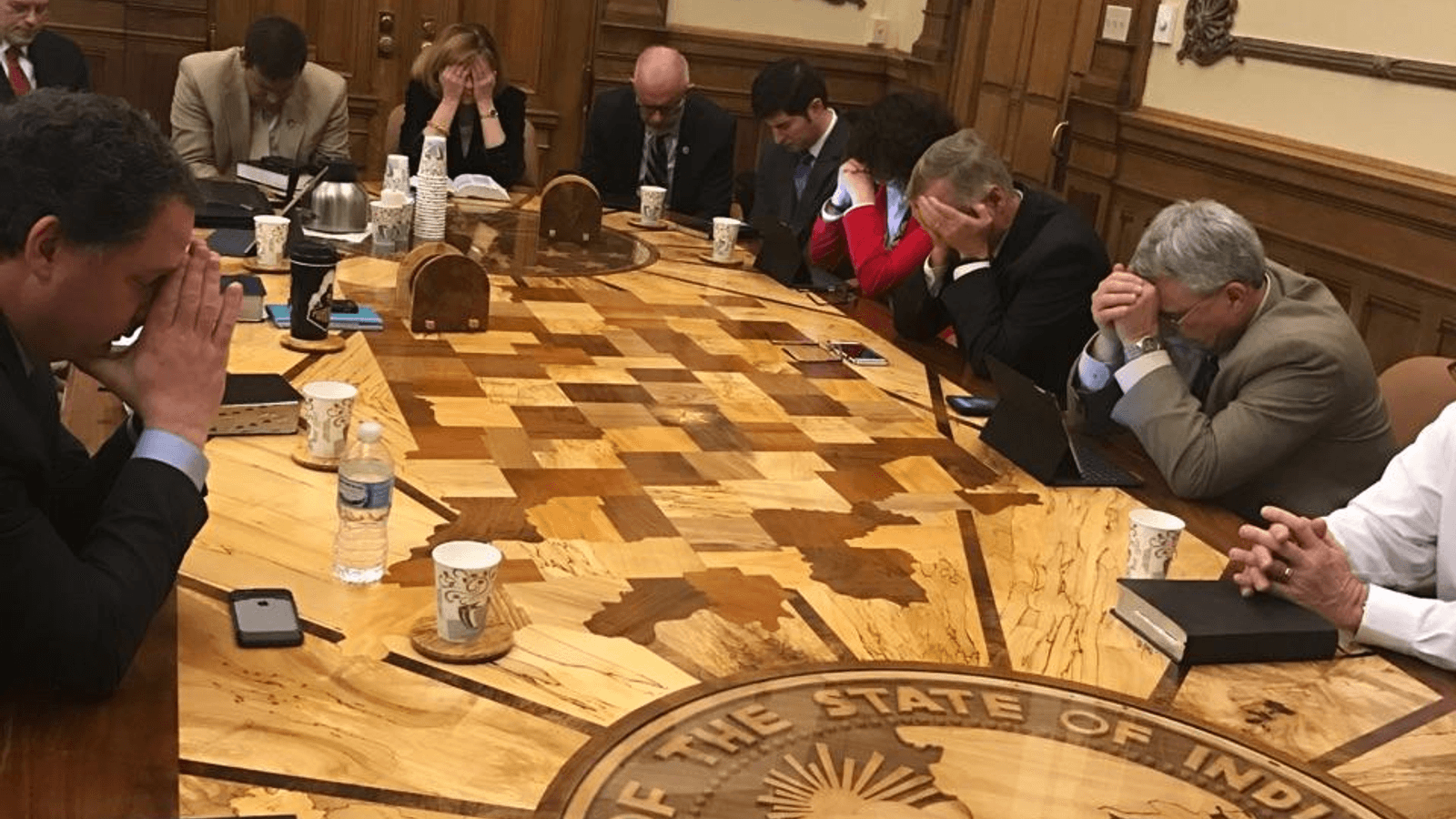 A picture of legislators praying during a legislators Bible study in the governors office