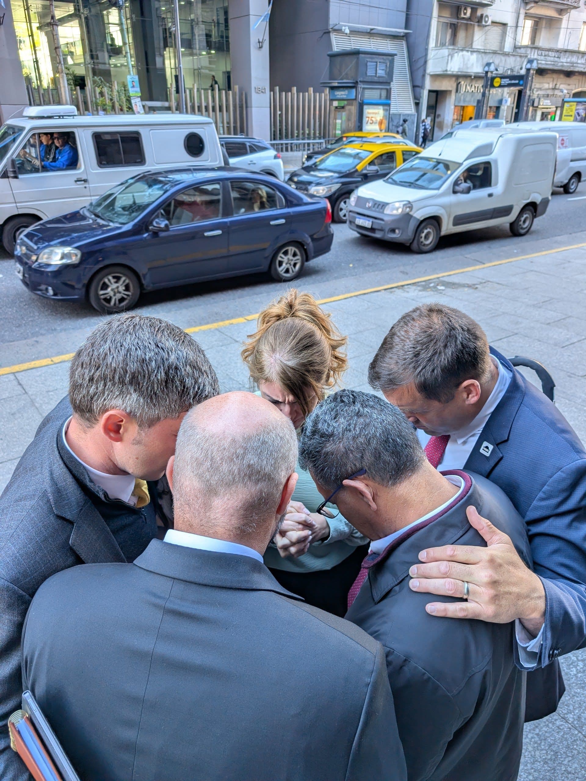Praying with a staffer outside the Argentine Capitol.