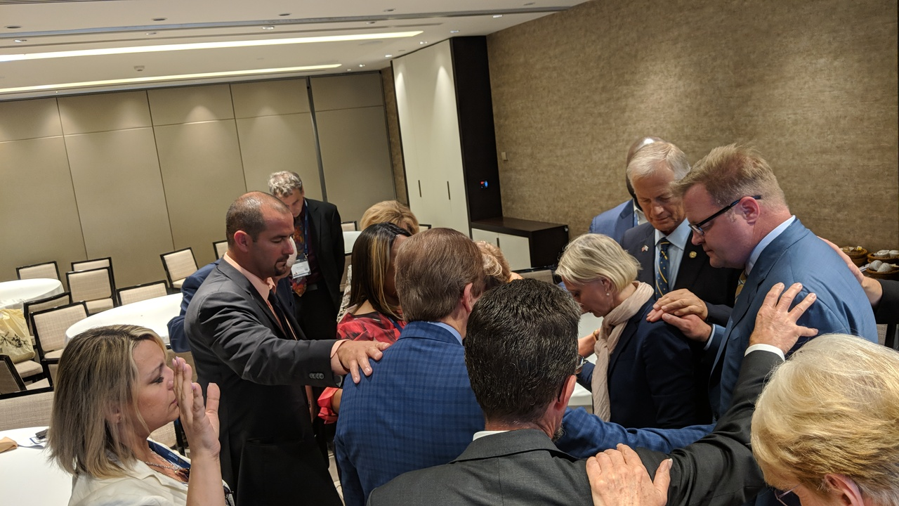 Legislators praying at the Jerusalem Prayer Breakfast