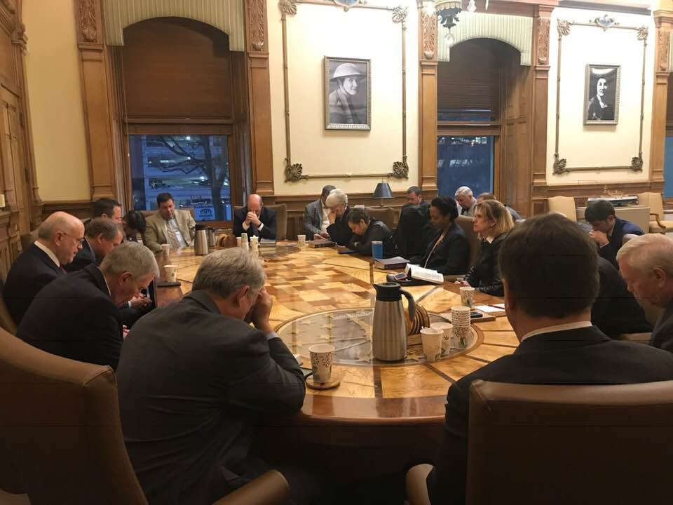 Chaplain Matthew Barnes praying at a Thursday morning Bible study in the Governors office